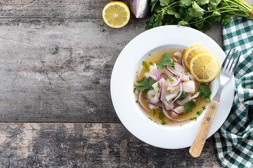 Traditional Peruvian ceviche sea bass fillet on wooden table. Top view. Copy space
