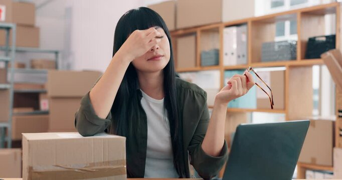 Eye strain, laptop and logistics with Asian woman in office for management of delivery or distribution schedule. Box, computer and stress with employee in supply chain depot for backlog or delay