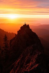 Adventurer on peak watching sunset over mountains with golden sky, stock image