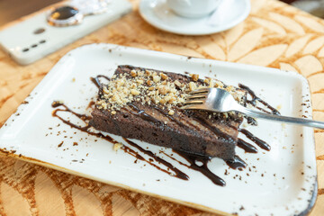 Decadent Chocolate Cake Garnished with Crushed Nuts and Artistic Drizzle