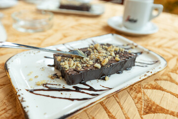 Decadent Chocolate Cake Garnished with Crushed Nuts and Artistic Drizzle