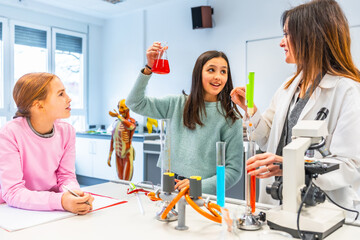 Students and teacher performing chemistry experiment in laboratory