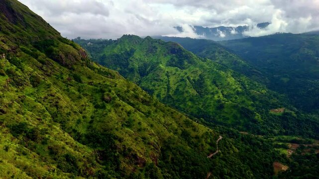 Drone aerial landscape of mountain range Kalthota highlands forest bushland vegetation with cloud haze fog at Ravana waterfalls park Ella Sri Lanka Asia nature travel tourism hiking
