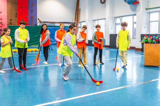 Students playing floorball in gym class at school