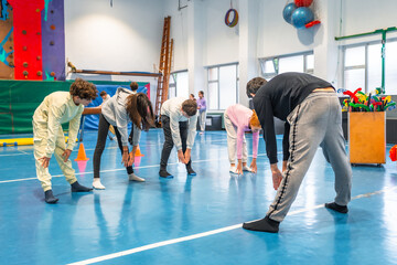 High school students stretching in gym class during physical education lesson