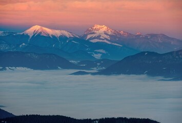 Mountain peak at sunset sunlight. Dramatic sunset with the sun setting behind mountain peaks,...