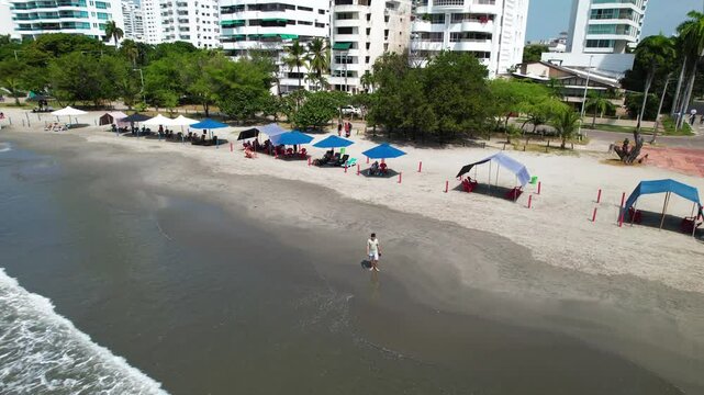 Tourist walking on bocagrande beach, cartagena, colombia