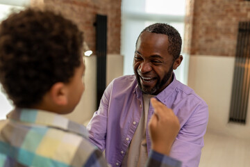 Father and son at home getting dressed in the kitchen and looking enjoyed