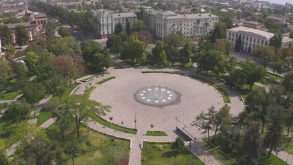 Fountain water square with green grass and tree Mariupol Ukraine 3 septemper 2020 year, tree park landscape, urban public refreshing, scenic peaceful sunlight, nature relaxing outdoor