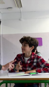 Dedicated teacher providing personalized academic support, guiding young student through challenging schoolwork in collaborative classroom environment