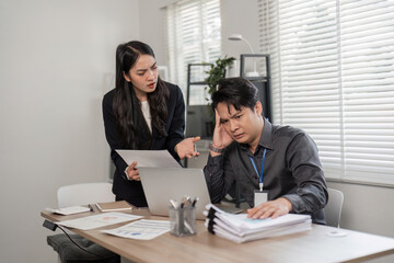 Business professionals discussing challenges in a modern office, expressing frustration and concern.