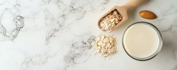 Fresh almond milk in glass with almond flour and whole almond on marble surface. This healthy beverage is perfect for smoothies and baking