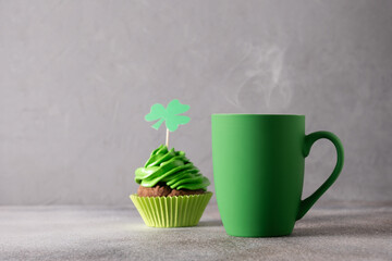 St. Patrick's Day food. Irish coffee in green cup and chocolate cupcake decorated whipped green...