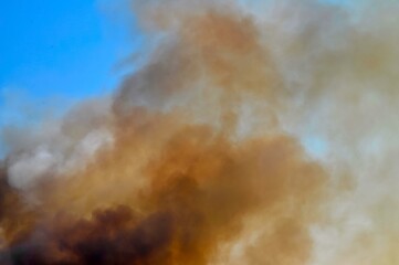 Clouds of smoke from a fire on the background of the sky