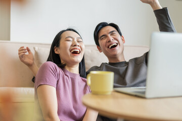 Young Asian couple using laptop at home