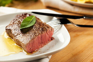 point steak, rare fried, with salt, pepper and melted butter, garnished with sage leaf
