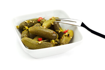 pickled cucumbers in square bowl with fork, isolated on white background