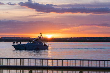 Barco pasando por el rio Guadiana al atardecer