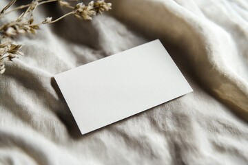 Blank white business card mockup on linen napkin with dry flowers