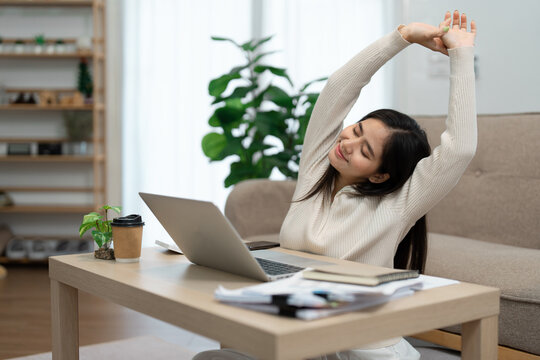 Stretching woman enjoying a break while working from home.