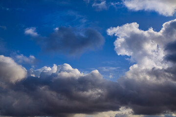 Dark clouds hang over the horizon, creating a striking contrast in the sky. Sun rays penetrate through the dense cloud cover, emphasizing the depth of the scene.