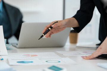 Business professional analyzing financial reports during a meeting, focusing on data presentation and strategy.