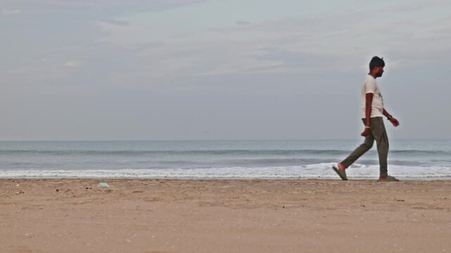 Indian person walking in gandhi beach or marina beach at Triplicane, Chennai, Tamil Nadu, india. sun set time, stable shot, 4k.