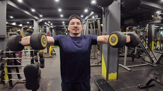 Young Man Performing Seated Dumbbell Lateral Raises for Shoulder Strength and Muscle Definition