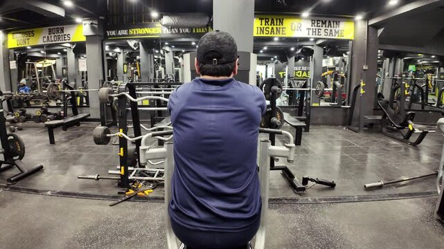 Young Man Performing Reverse Pec Deck Fly on Machine &ndash; Rear Delt Workout, Shoulder Strength, Muscle Building, Gym Training, and Fitness Exercise
