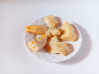 Close up of fresh peeled and cut ginger in a plate isolated on white background.