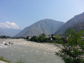 A river with a mountain in the background. Tosh, Himachal Pradesh, India
