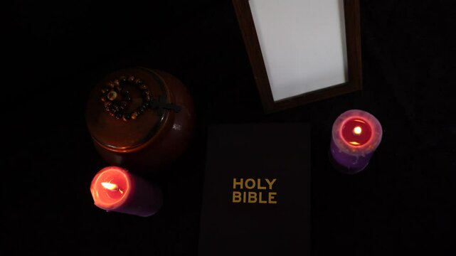       funeral, photo frame, candles, marble urn for ashes, holy bible and spiritual bracelet with black cross