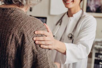 Doctor Supporting an Elderly Patient Showing Care and Compassion in a Clinical Setting