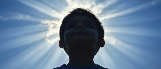A silhouette of a young boy against a radiant sky, with beams of sunlight creating a halo effect, evoking a sense of wonder and innocence