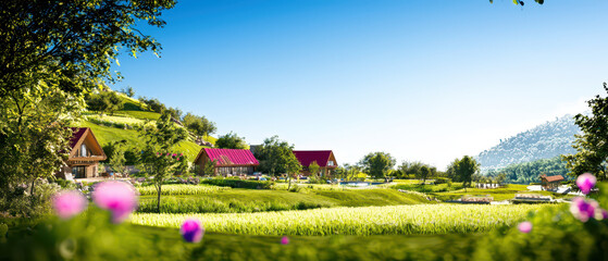 Obraz premium A serene landscape featuring colorful houses, lush green fields, and vibrant flowers under a clear blue sky.