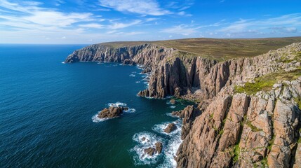 Obraz premium A cliffside view looking down at waves crashing against the rocks.