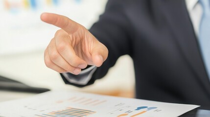 A businessman with an elegant suit points decisively at a report or chart, emphasizing a point in a professional setting. European descent evident.