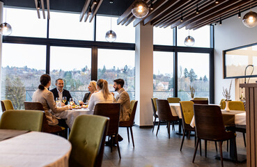 Smiling coworkers in restaurant talking during business lunch.