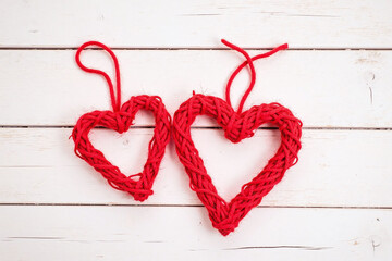 two red heart shaped twine ornaments wooden surface rustic