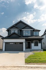 Fototapeta premium This contemporary two-story home features a generous garage and a beautifully maintained lawn, nestled within a charming suburban neighborhood beneath a bright and clear blue sky