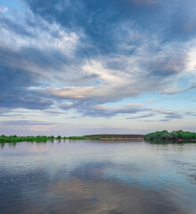 Fototapeta premium Calm lake with a cloudy sky in the background