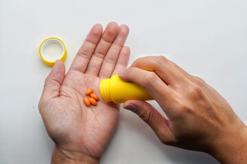Closeup photo of supplements with a yellow bottle. take omega 3, multivitamins, vitamins B, C, D,...