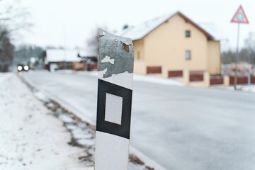 Worn Road Sign with Snow and Blurry Background