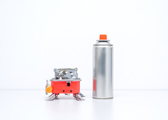 Portable gas stove for camping with a cylinder on a white background. Replaceable gas cylinder and...