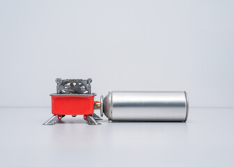 Portable gas stove for camping with a cylinder on a white background. Replaceable gas cylinder and...