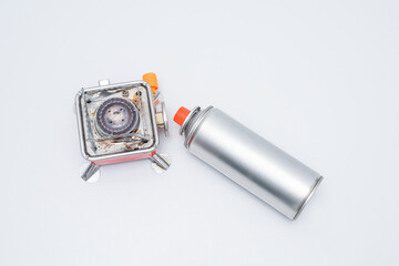 Portable gas stove for camping with a cylinder on a white background. Replaceable gas cylinder and...