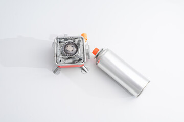 Portable gas stove for camping with a cylinder on a white background. Replaceable gas cylinder and...