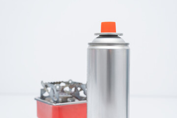 Portable gas stove for camping with a cylinder on a white background. Replaceable gas cylinder and...