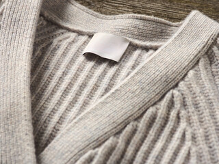 Detailfoto Closeup vom Kragen einer gelegten grauen Cashmere Strickjacke mit Label