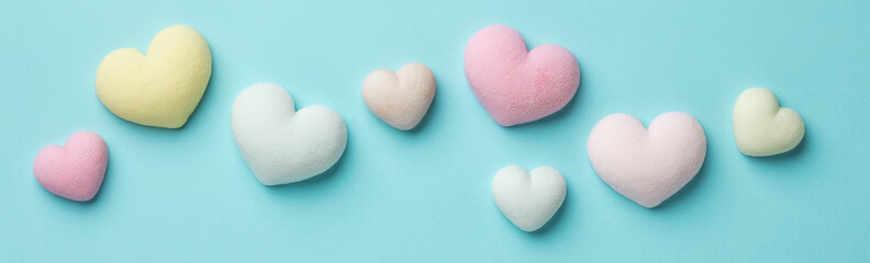 Colorful tiny hearts on pastel blue background. Minimal concept idea. Top view.